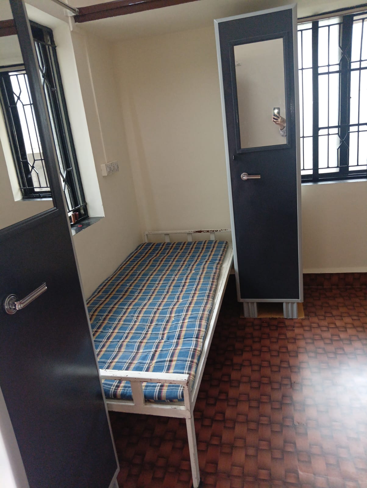 Single room with bed and wardrobe at Queen Quatters girls PG Nigdi Pune