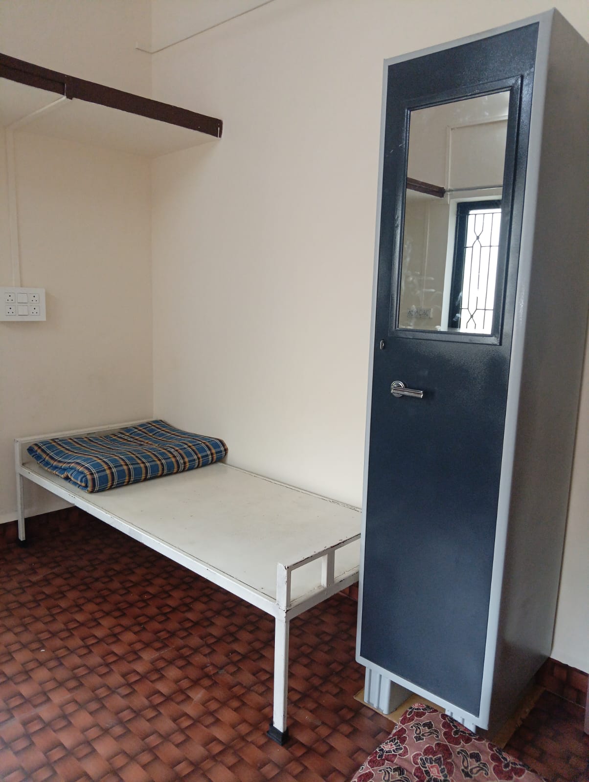 Single bed with personal wardrobe storage at Queen Quatters PG Pune